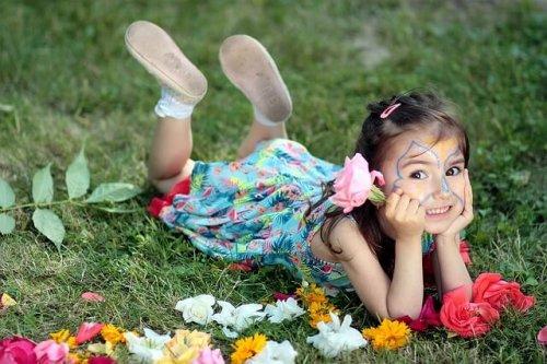 bambina sdraiata in mezzo al prato