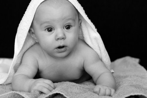 Bambino sotto a un asciugamano