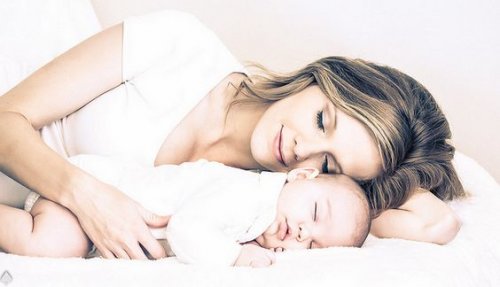 Mamma sdraiata con neonato