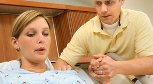 donna che partorisce con marito