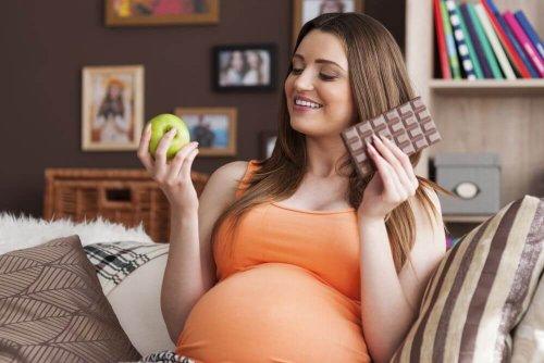 donna incinta con mela e cioccolato