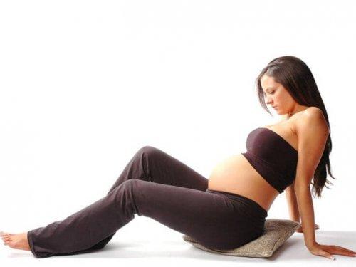 donna incinta seduta su cuscino 