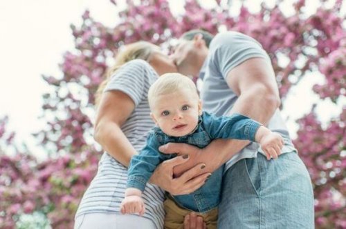genitori che si baciano con figlio in braccio