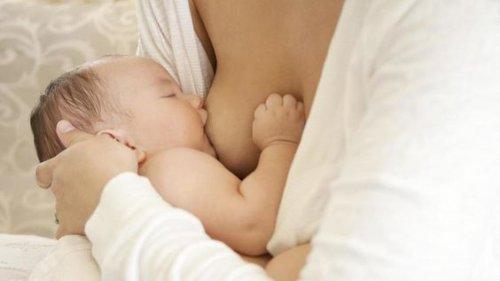 mamma che allatta bebè al seno 