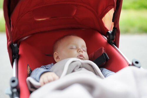 Neonato che dorme nel passeggino