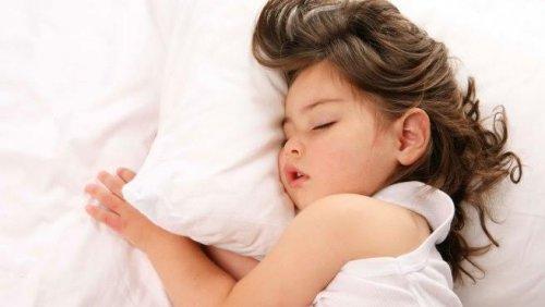 bambina che dorme sui cuscini