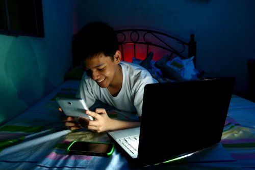 bambino con tablet sul letto dorme tardi