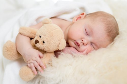 bambino che abbraccia peluche mentre dorme