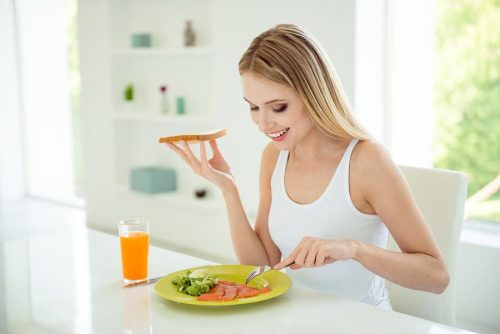 donna che mangia pesce a tavola