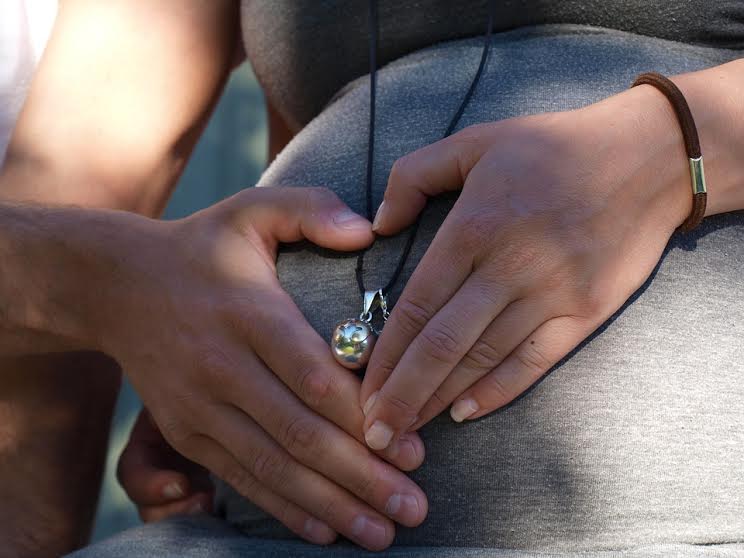 Donna incinta con una collana