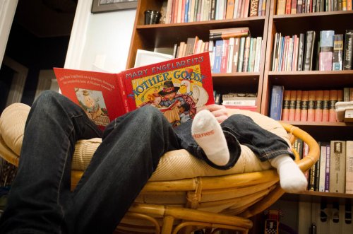 padre che legge fiaba al figlio sul divano