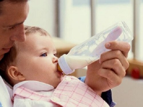 Papà dà il biberon al figlio