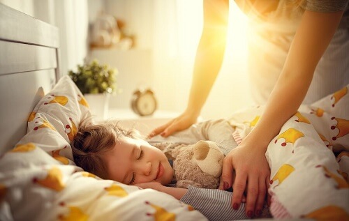 bambina dorme nel letto con la mamma sopra