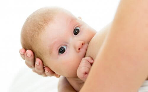 bambino con occhi aperti prende il seno
