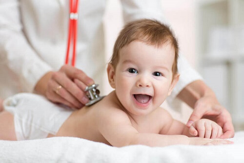 bambino sdraiato mentre medico lo ausculta