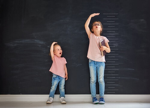 due bambine misurano l'altezza vicine