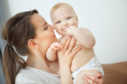 giovane mamma tiene in braccio bimbo piccolo