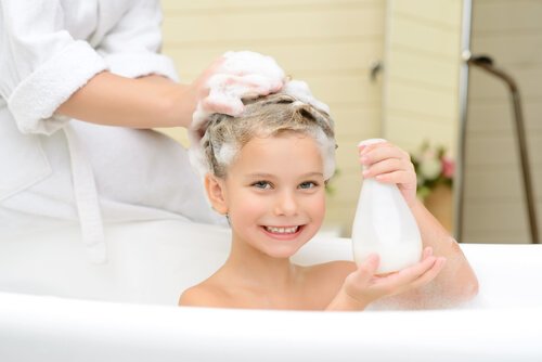 madre lava i capelli al bambino nella vasca