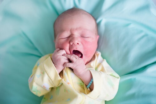 un neonato con guance arrossate e bocca aperta