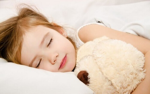 Bimba dorme con peluche