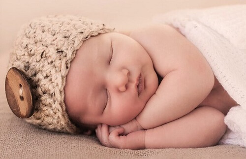 Bebè con cappellino dorme