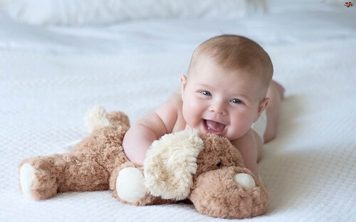 Neonato sorridente con peluche