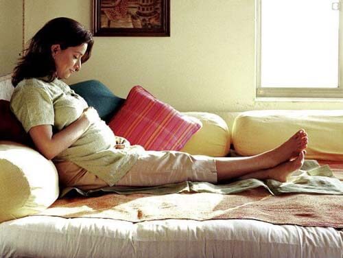 Donna incinta riposa sul divano