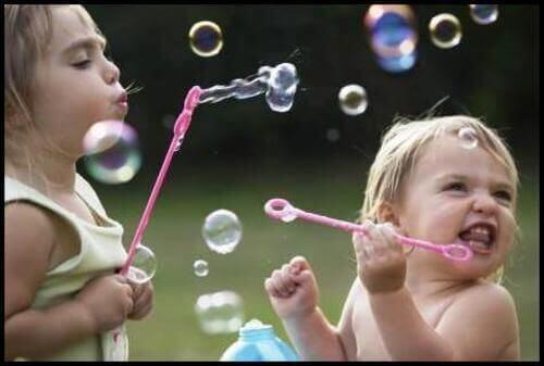 Bimbe giocano con bolle di sapone