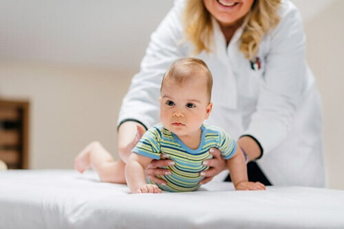 Pediatra donna tiene bimbo su lettino