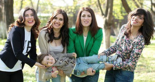 Quattro donne tengono bambino