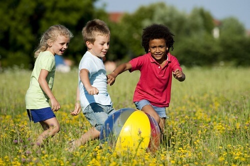 Tre bimbi corrono sul prato