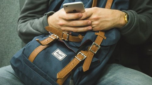 Uomo usa telefonino su borsa