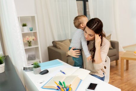 Mamma studia con bambino in braccio