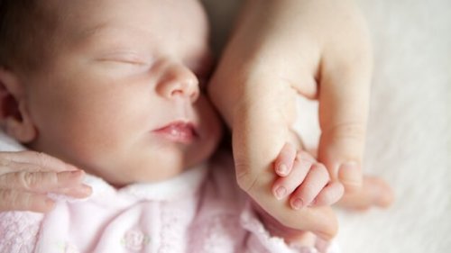 neonato tiene la mano della mamma