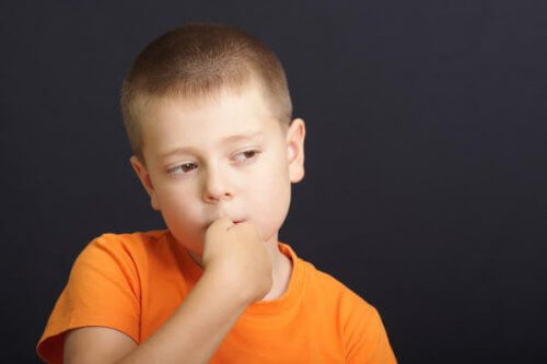 Bambino con le mani in bocca come evitare che i figli si mangino le unghie