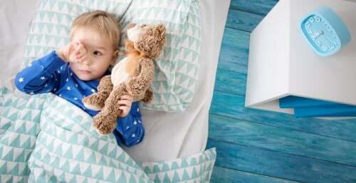 Bambino a letto con peluche