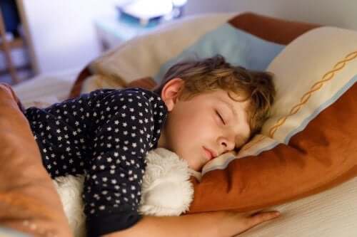 bambino che dorme a letto con orsetto