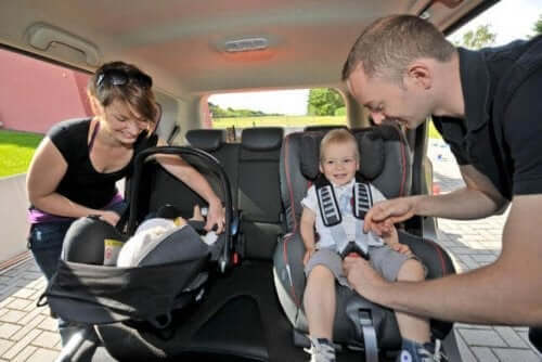 mamma e papa sistemano seggiolini auto per bambini in macchina