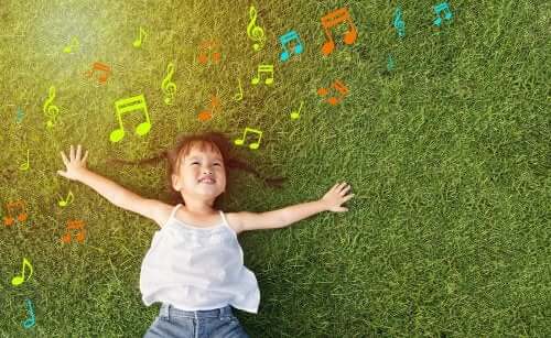 Bambina che ascolta la musica sul prato