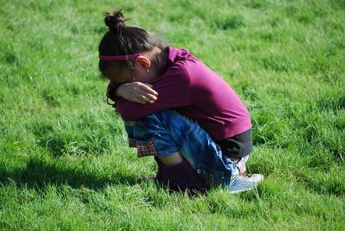 Bambina introversa piange in un prato