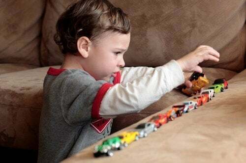Bambino con autismo gioca con le macchinine