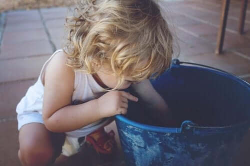 Bambino mancino con un secchio blu