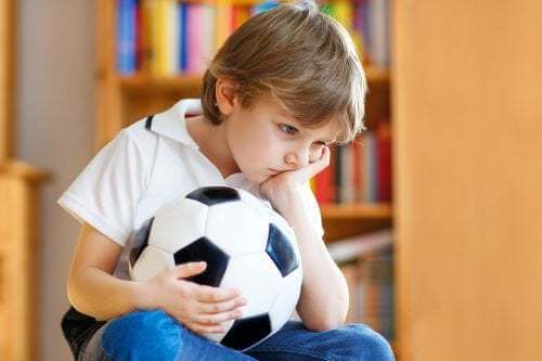Bambino infelice con un pallone in mano