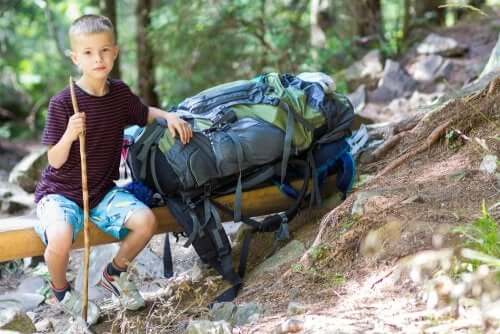 Bambino seduto in un bosco