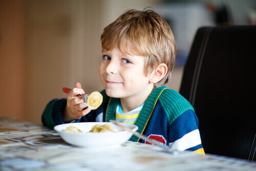 Bambino che impara a mangiare sano