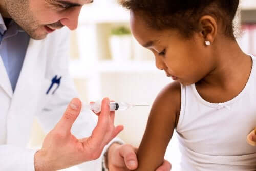 Medico che vaccina una bambina