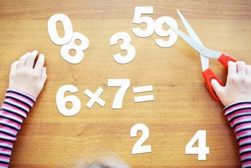 Bambino che ritaglia numeri di carta