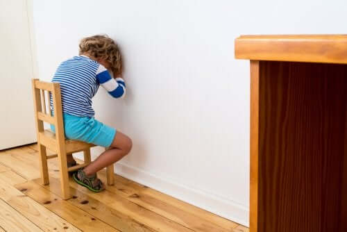 bambino seduto faccia al muro per castigo