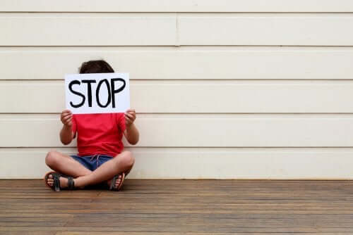 Bambino con cartello stop alla violenza su minori