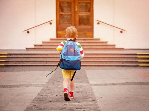 Bambino che entra a scuola.